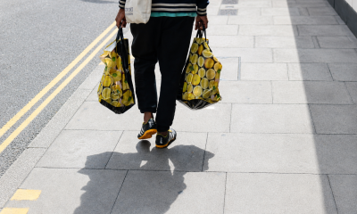 A man carrying two plastic bags on the street