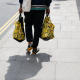 A man carrying two plastic bags on the street